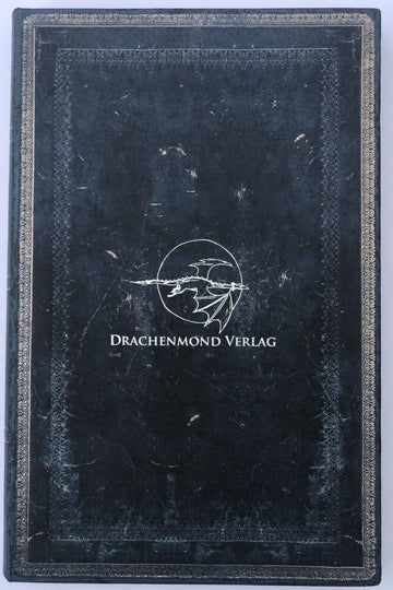 Das Produktbild zeigt das Paperblank. Mittig ist das Drachenmond Verlagslogo - ein fliegender Drache vor Vollmond, darunter der Verlagsname - auf dunkelblauem Hintergrund abgebildet. Den Rand ziert ein silberner Schmuckrahmen.
